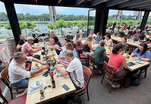 Praxisausflug 02 Gemeinsame Einkehr des Praxisteams während des Fahrradausflugs in einem Restaurant mit Blick aufs Wasser.